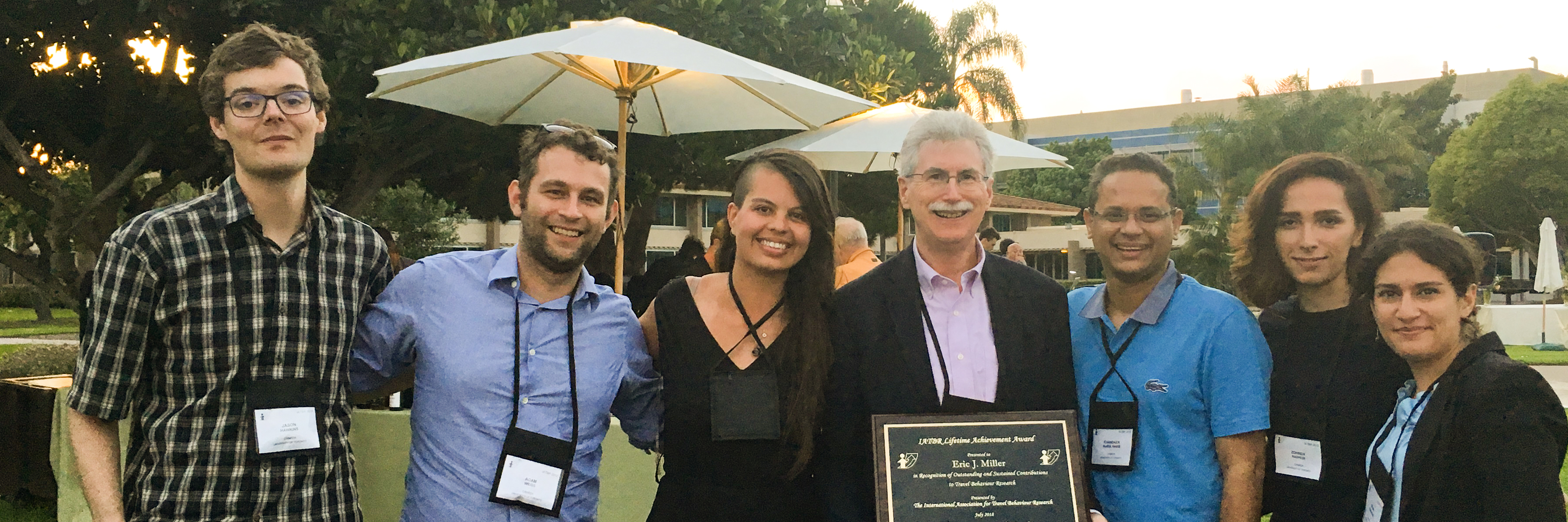 Group surrounds Eric Miller holding his IATBR Lifetime Achievement Award plaque