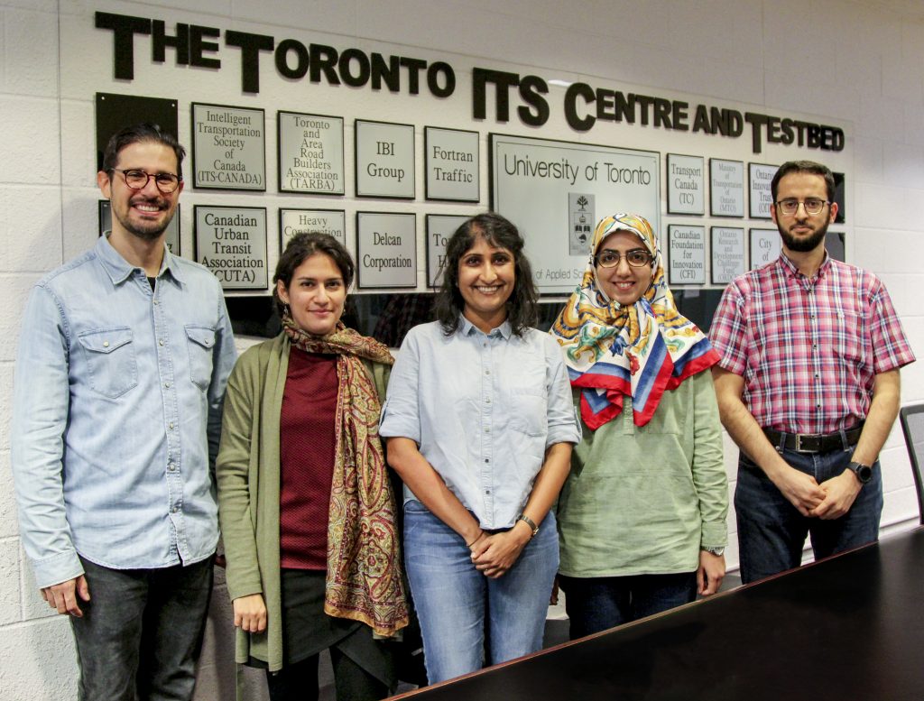 Group stands in front of wall plaques entitled "The Toronto ITS Centre and Testbed"