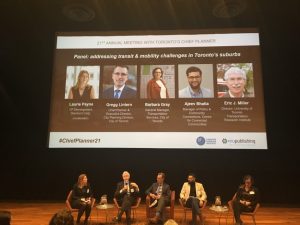 Five panelists on stage under huge screen