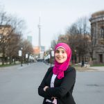 Toka Mostafa standing on King's College Circle with CN Tower in backgroun