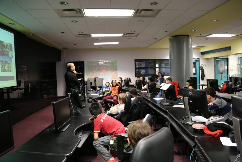 Professor discusses with class in computer lab
