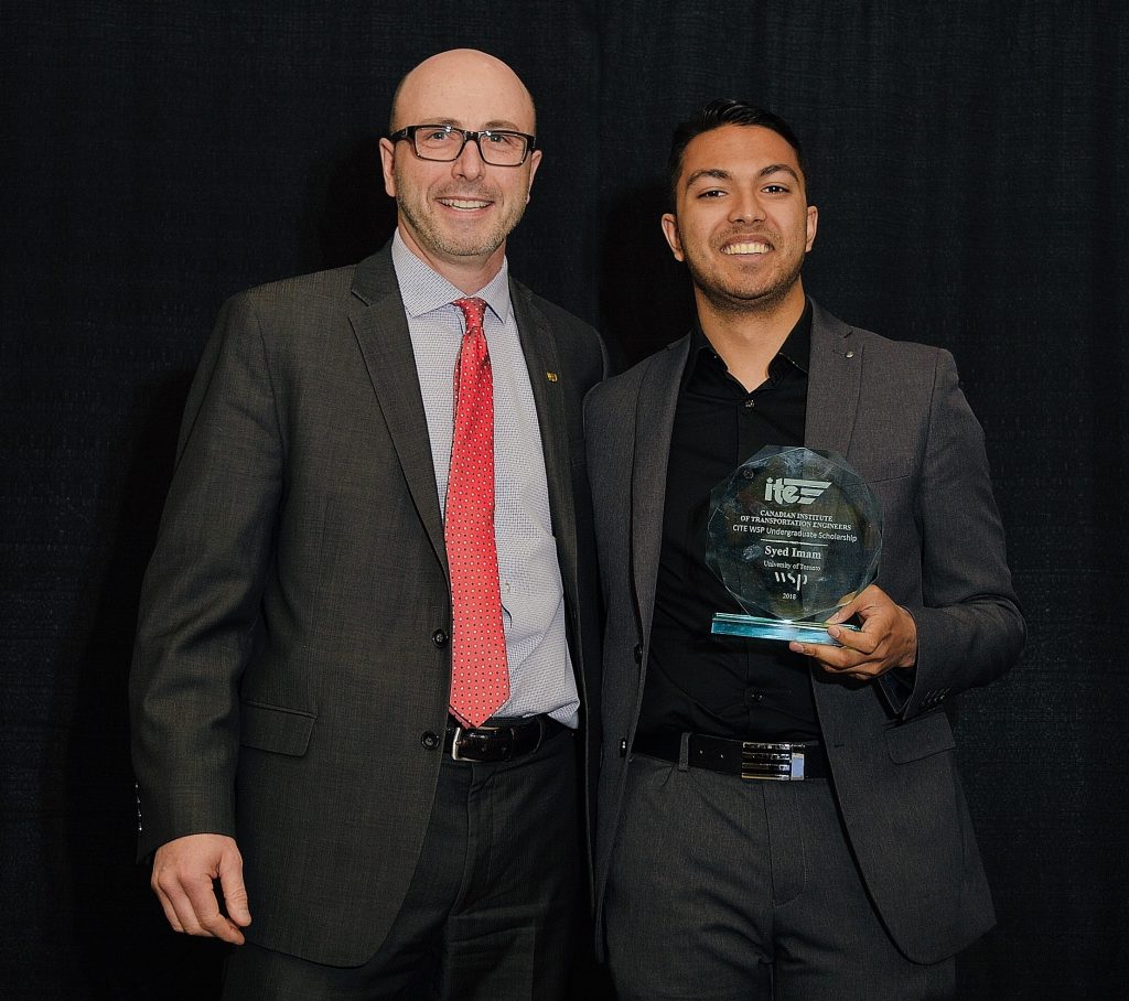 Presenter poses with award-holding recipient