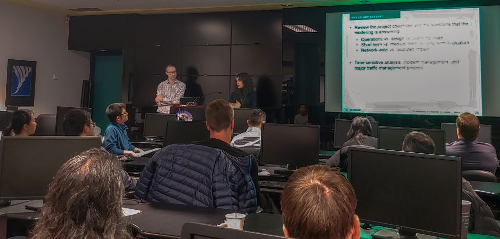 Two presenters in dark computer lab