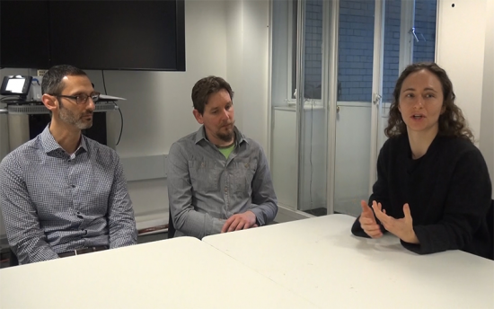 Three in discussion around a table