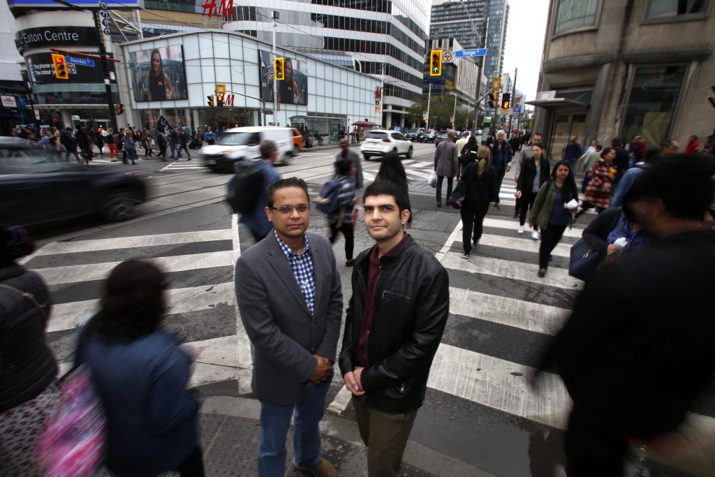 two stand still in busy pedestrian crossing