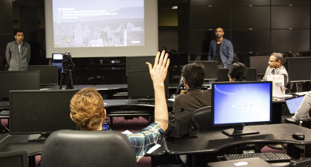 two speakers, audience hand in the air