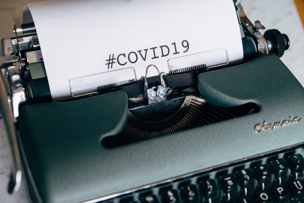 manual typewriter with #COVID19 typed on white paper